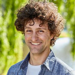 A person with curly hair smiling
Description automatically generated