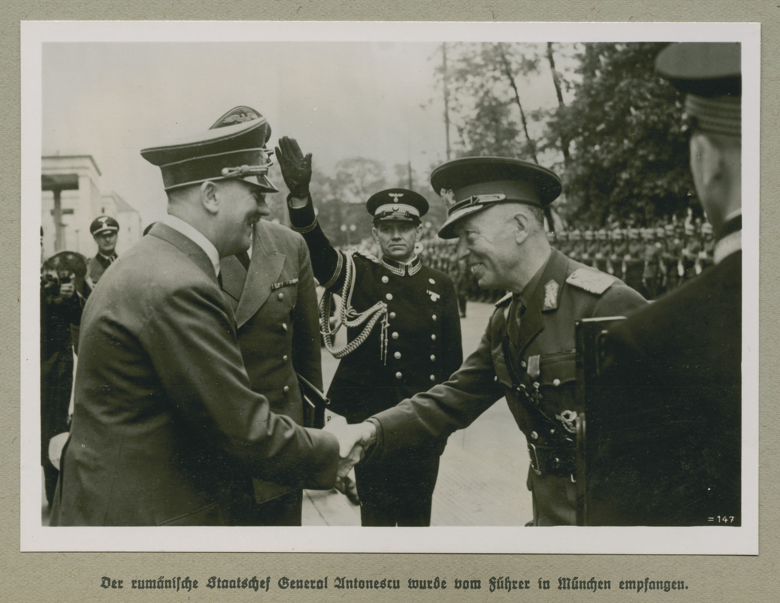 Adolf Hitler shakes hands with Prime Minister of Romania Ion Antonescu.
The original caption reads: The Romanian head of state Antonescu was welcomed by the Führer in Munich.