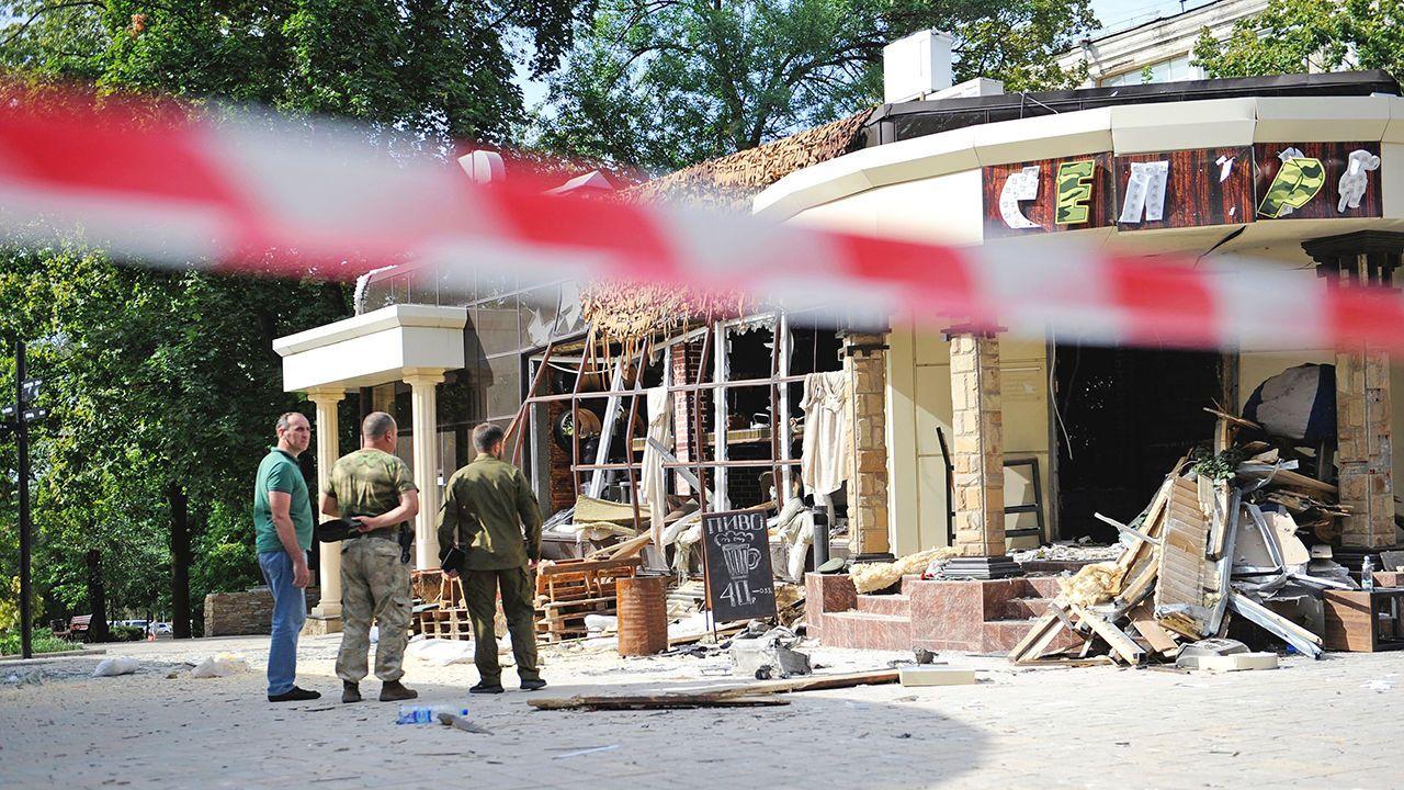 Men stand outside the bomb-damaged restaurant where Alexander Zakharchenko was killed, in Donetsk.