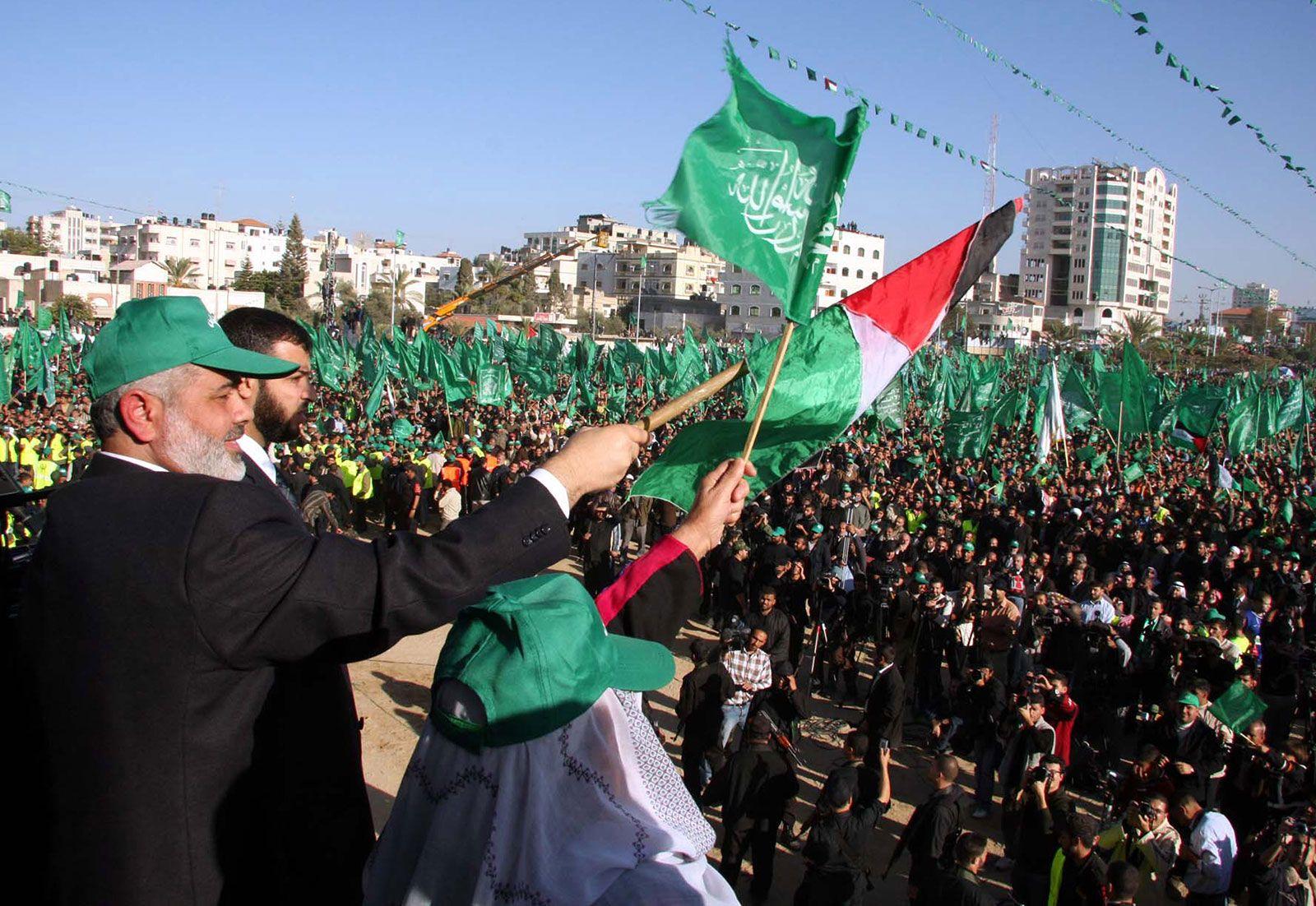 A group of people holding flags
Description automatically generated