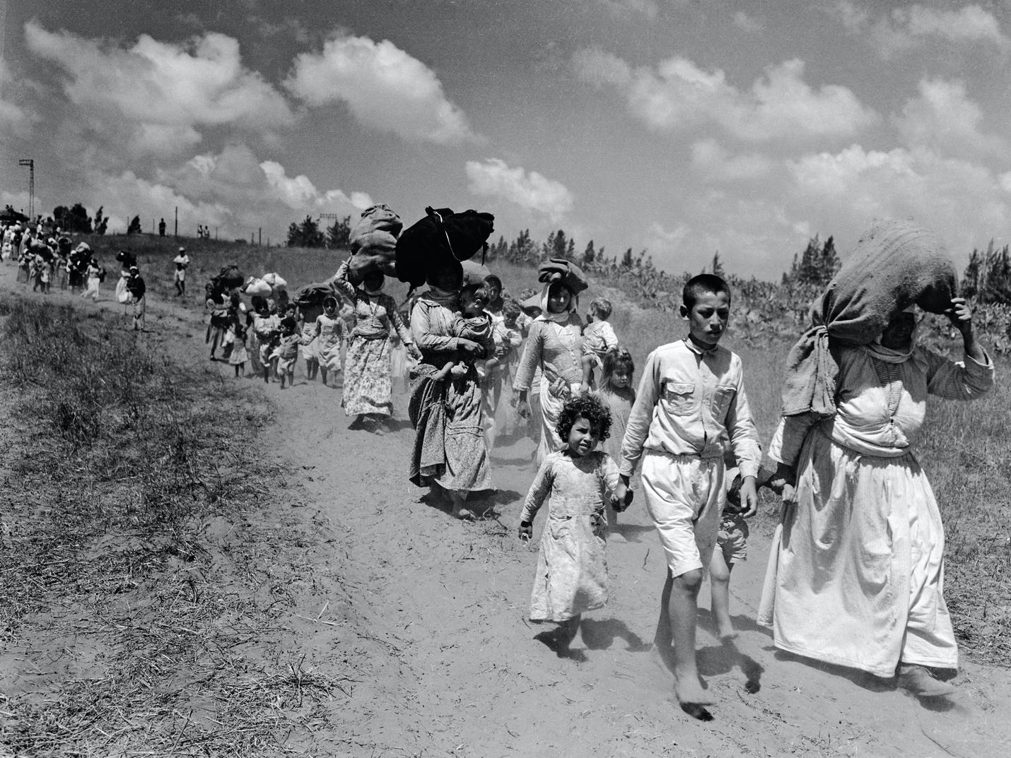 A group of people walking on a dirt road

Description automatically generated