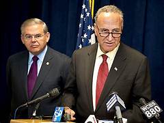 A person in suit and tie standing next to another person in suit and tie

Description automatically generated