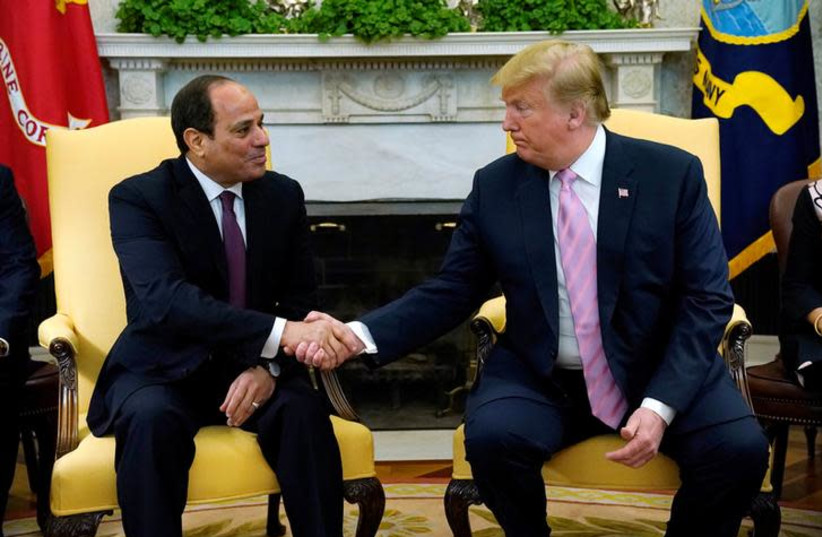 A person in suit shaking hands with another person in a chair

Description automatically generated