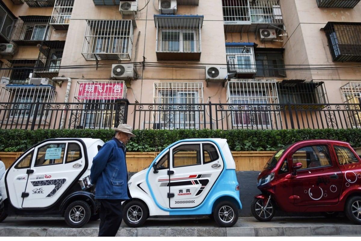 A person walking next to a small car

Description automatically generated