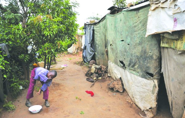A person washing her face in a slum Description automatically generated