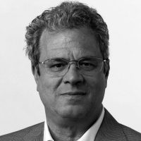 A person wearing glasses and a suit

Description automatically generated