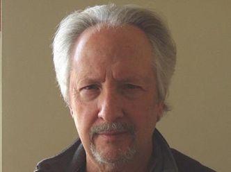 A person with grey hair and a goatee

Description automatically generated