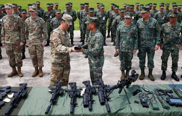 United States Army Col. Ernest Lee, center left, with Philippine Marine Maj. Gen. Emmanuel Salamat during a handover of counter-terrorism weapons in Taguig, east of Manila, last week.