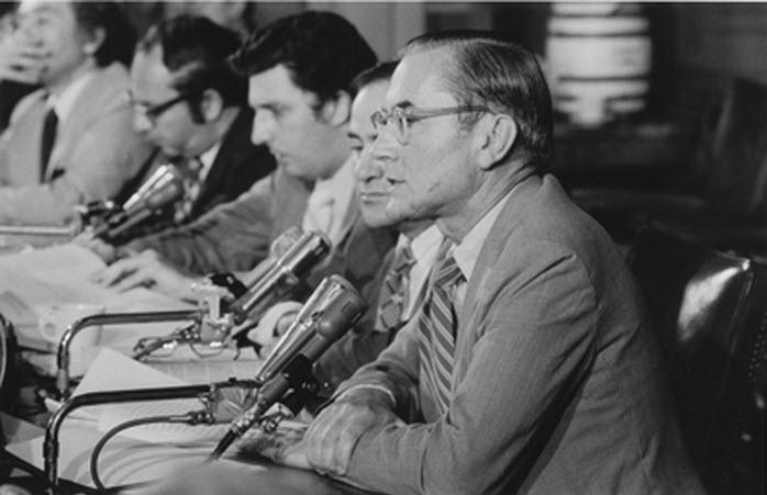 A group of men sitting at a table with microphones

Description automatically generated with medium confidence