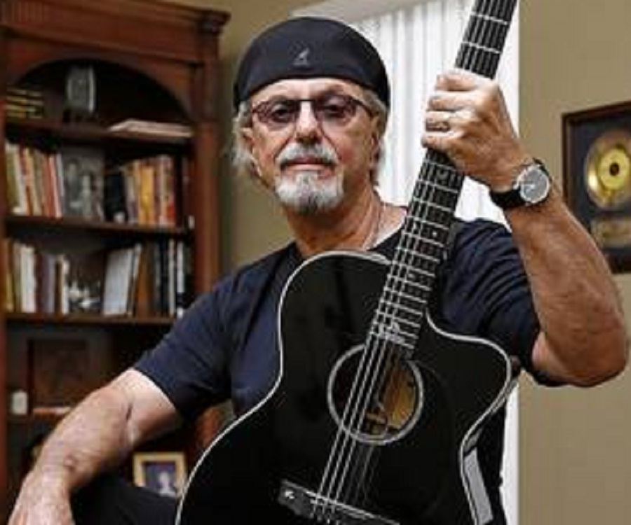 A person holding a guitar

Description automatically generated