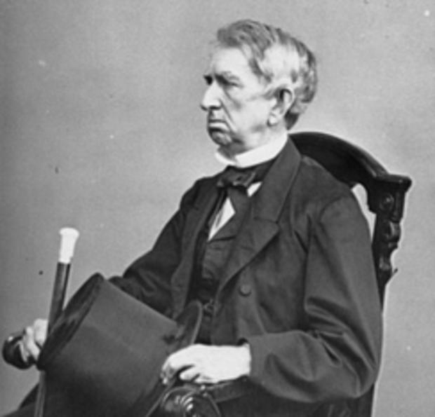 A person sitting in a chair holding a top hat
Description automatically generated with medium confidence