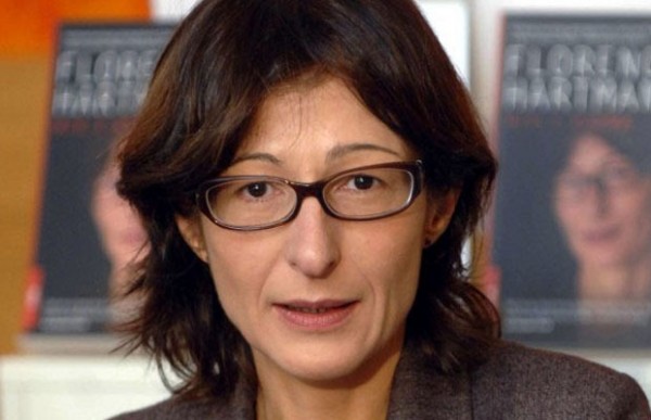 A person with glasses and a brown jacket
Description automatically generated