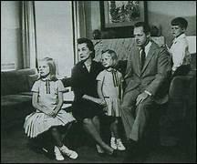 A family sitting on a couch
Description automatically generated