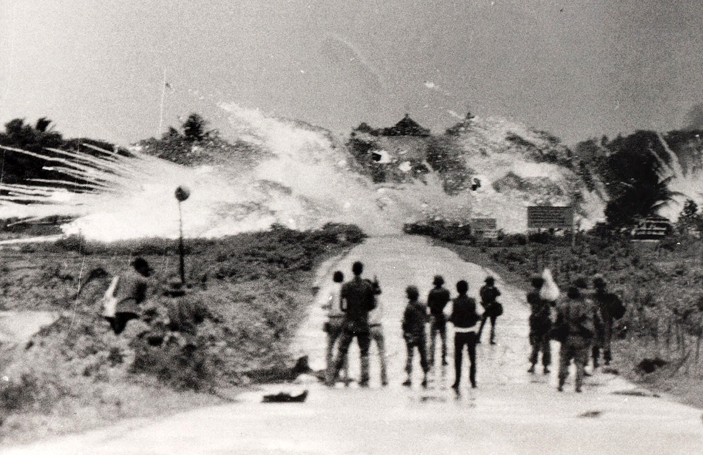A group of people standing on a road

Description automatically generated