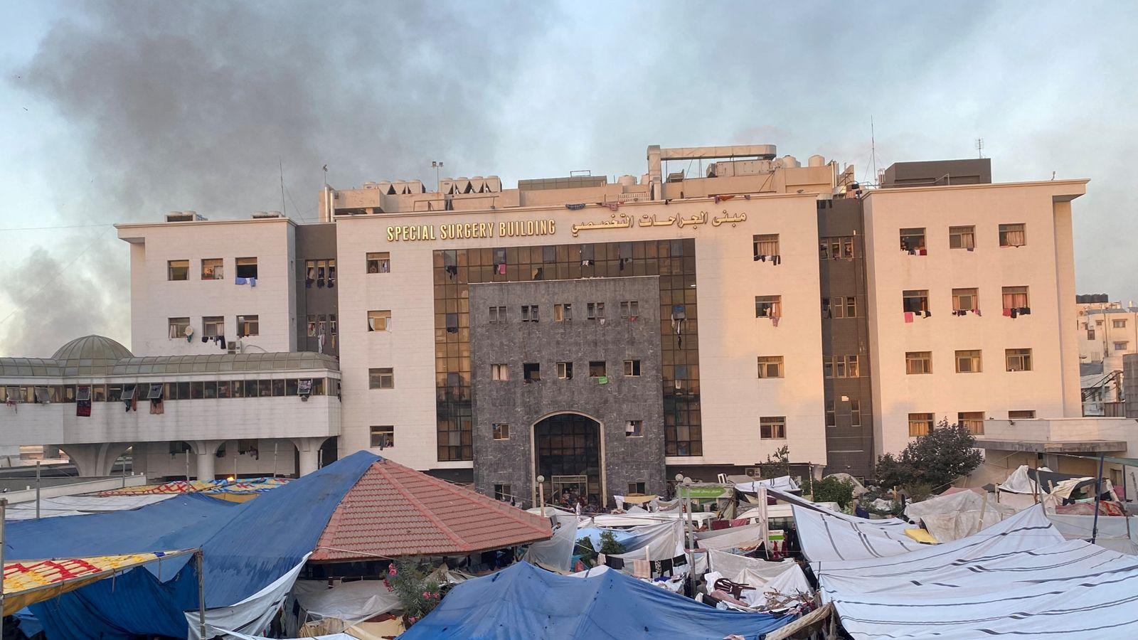 A large building with tents in front

Description automatically generated