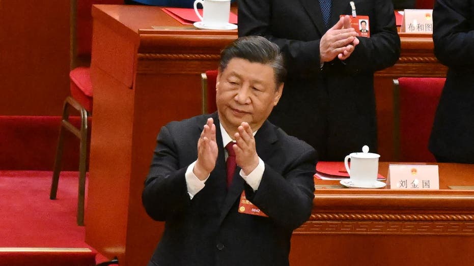 A person in a suit clapping

Description automatically generated