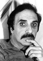 A person with a mustache and a finger on his chin
Description automatically generated with low confidence