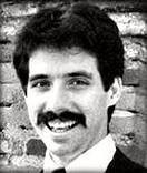 A person with a mustache smiling

Description automatically generated