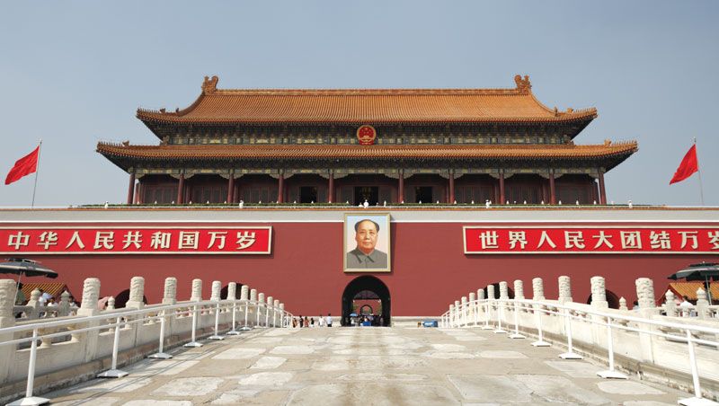 A red building with a picture of a person on the front with Tiananmen Square in the background

Description automatically generated
