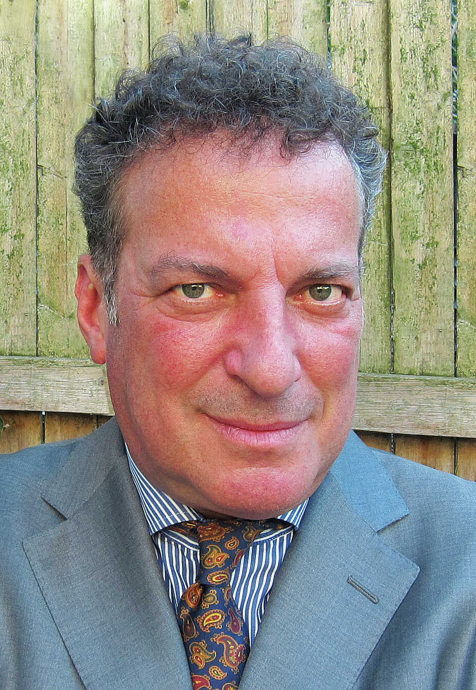A close-up of a person in a suit

Description automatically generated