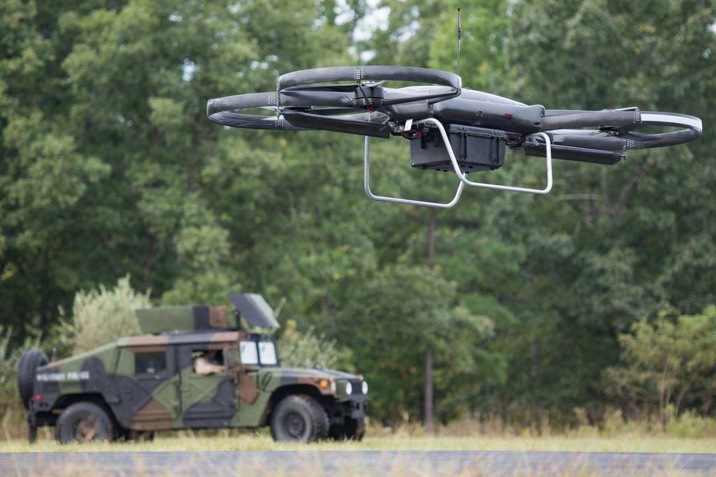 A drone flying over a military vehicle
Description automatically generated