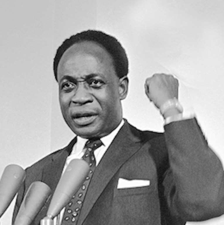 A person in a suit and tie holding his fist up
Description automatically generated