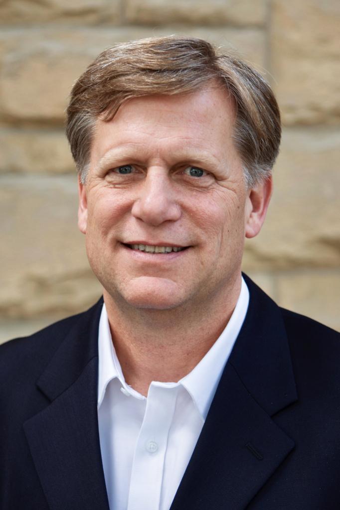 A person in a suit smiling

Description automatically generated