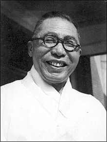 A person wearing glasses and smiling
Description automatically generated