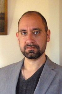 A person with a beard and mustache

Description automatically generated
