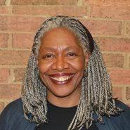 A person with grey hair and a black shirt

Description automatically generated