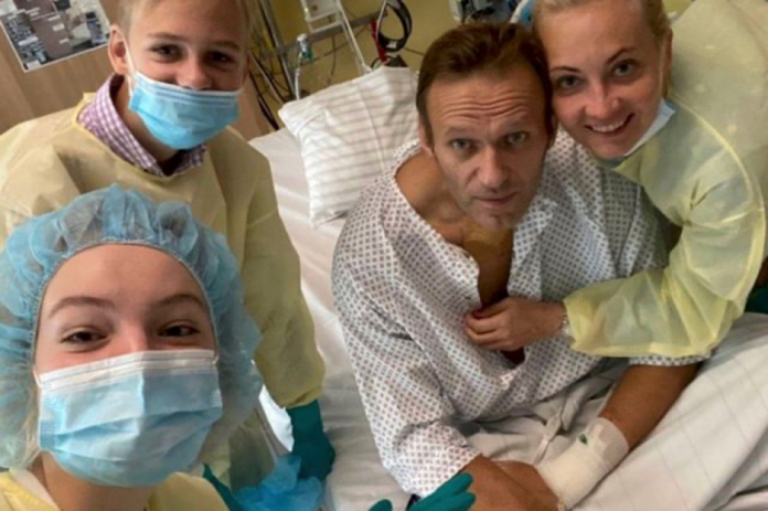 A group of people in hospital gowns and masks Description automatically generated