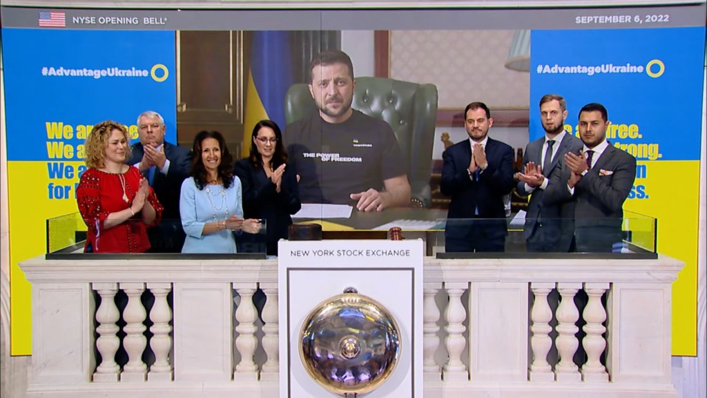 A group of people standing in front of a screen

Description automatically generated