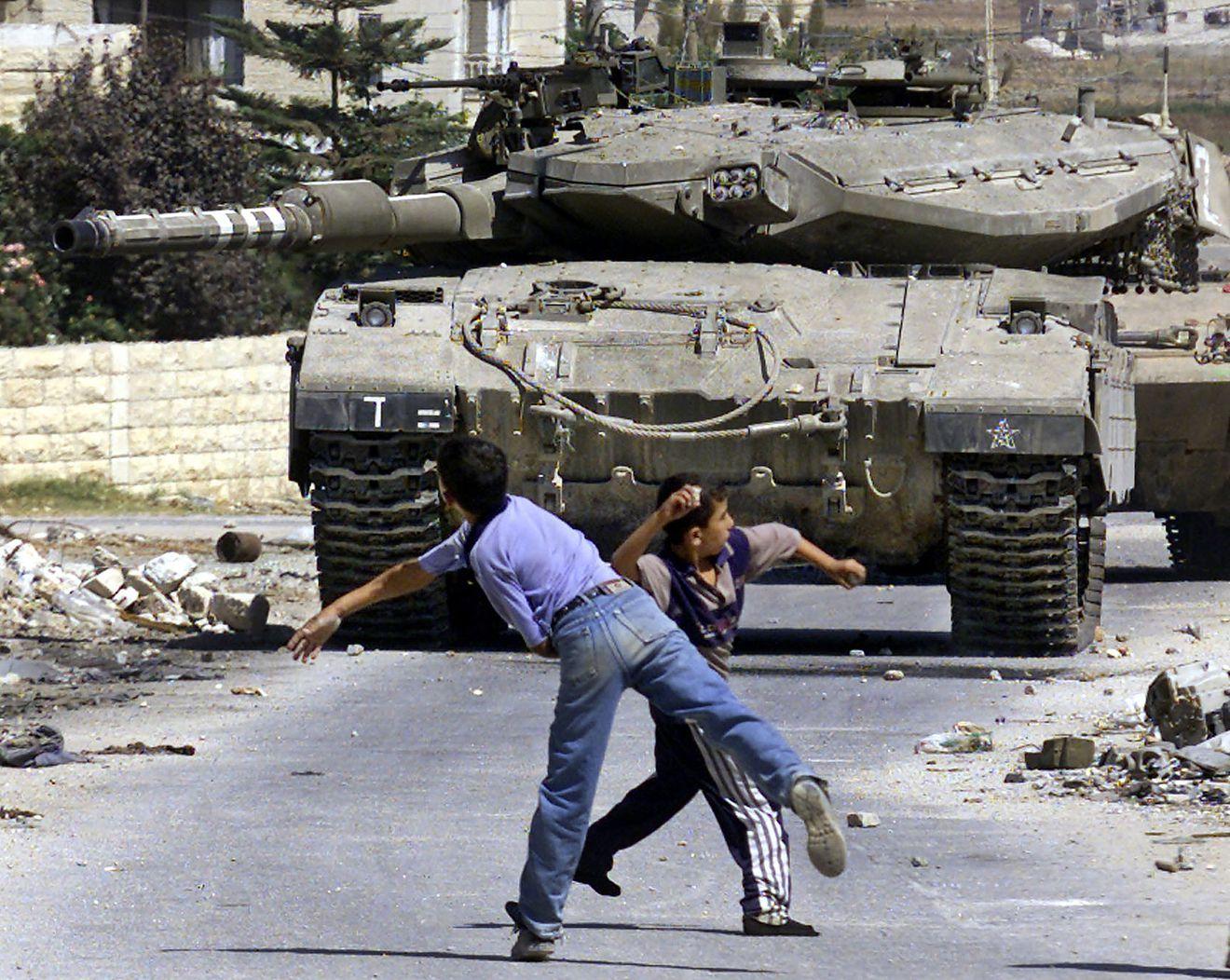 A person and child running near a tank

Description automatically generated