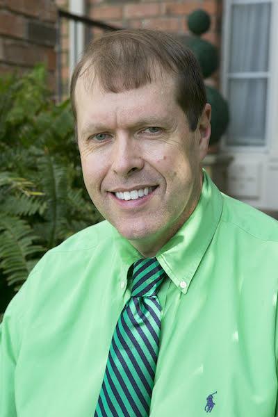 A person in a green shirt and tie

Description automatically generated