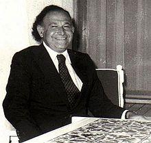A person in a suit and tie smiling
Description automatically generated