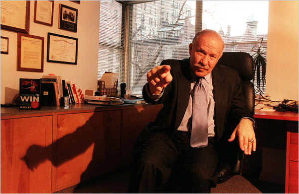 A person in a suit pointing at something

Description automatically generated