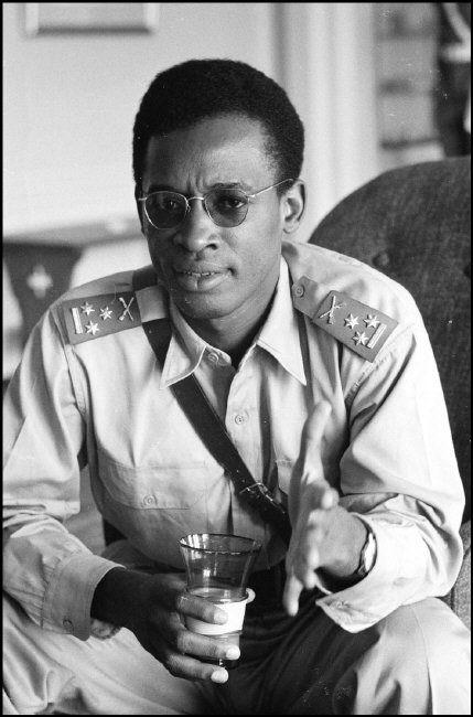 A person in military uniform holding a glass
Description automatically generated