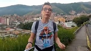 A person standing outside with a city in the background

Description automatically generated