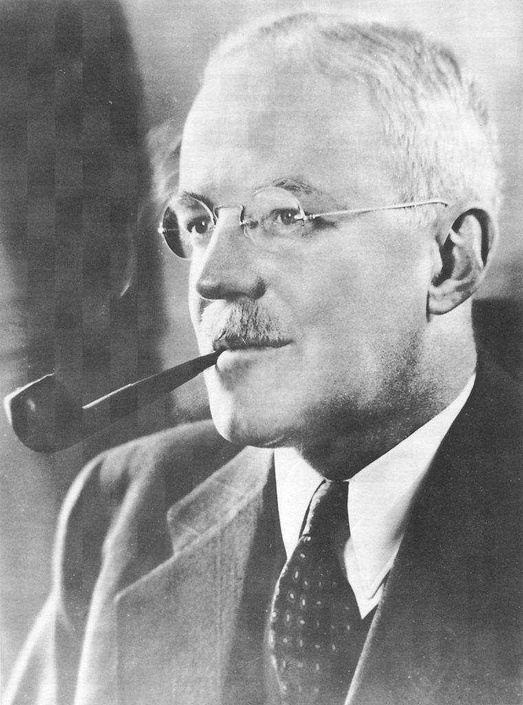 A person with a pipe in his mouth
Description automatically generated