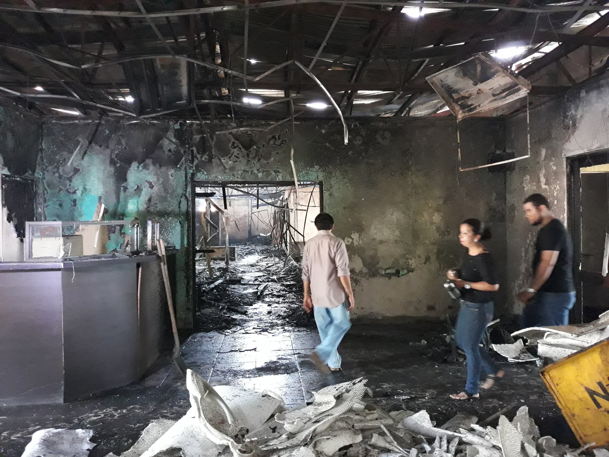 A group of people walking in a destroyed building
Description automatically generated