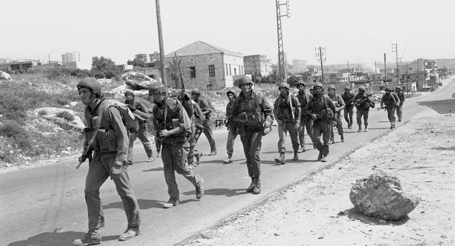 A group of soldiers marching on a road

Description automatically generated