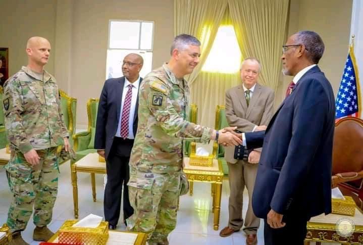 A military person shaking hands with other men

Description automatically generated