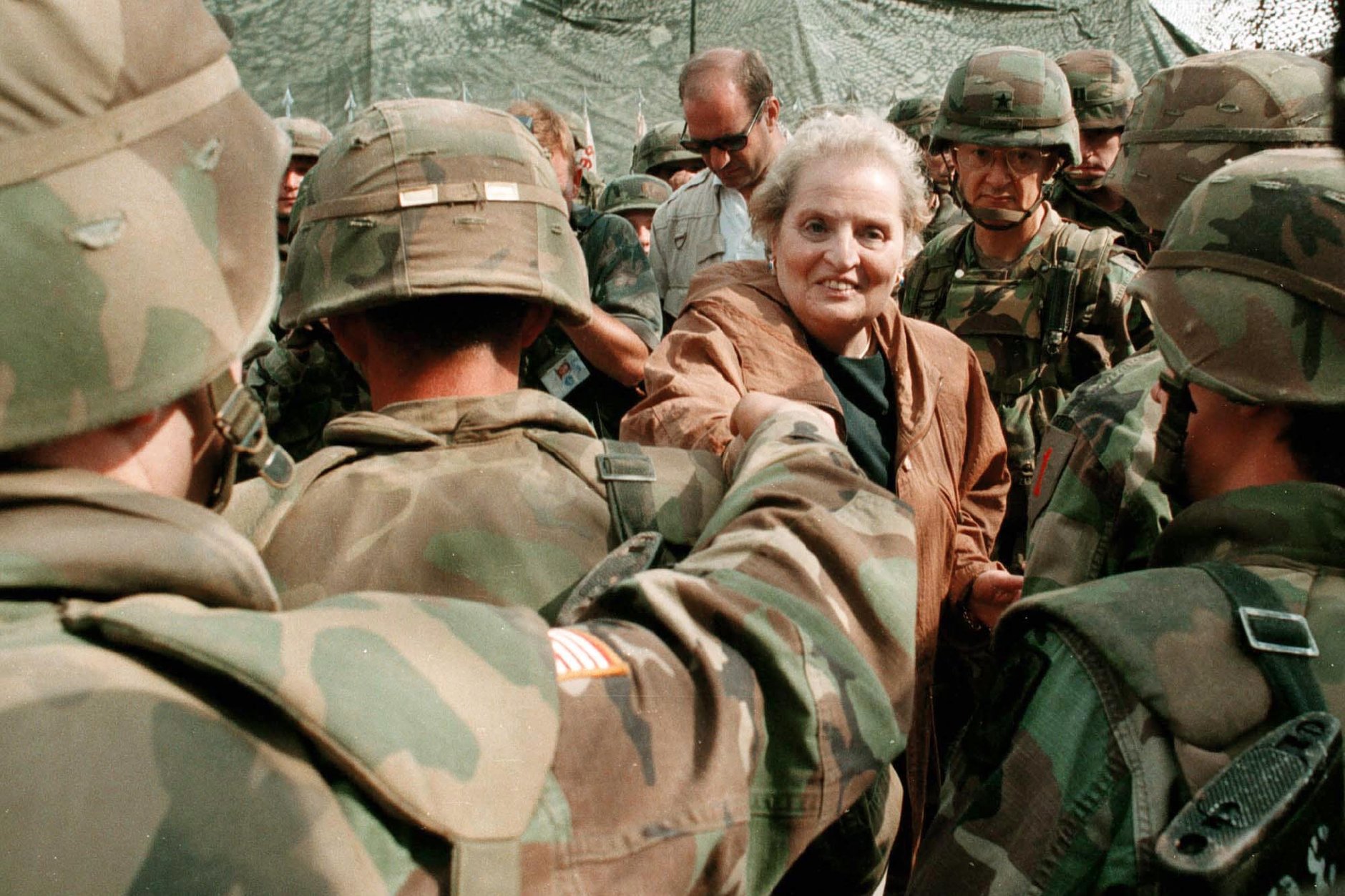 A person shaking hands with soldiers

Description automatically generated