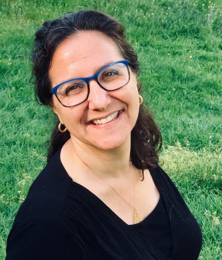 A person wearing blue glasses and smiling

Description automatically generated