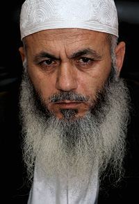 A person with a white beard

Description automatically generated