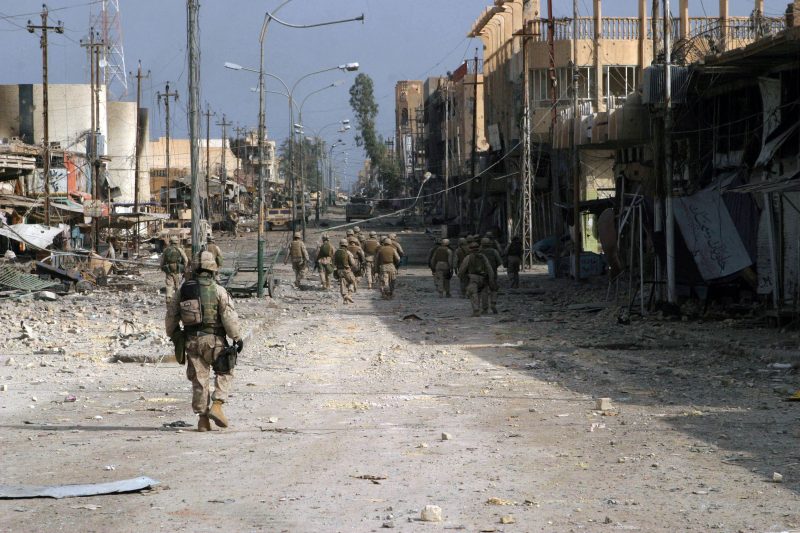 A group of soldiers walking down a street

Description automatically generated