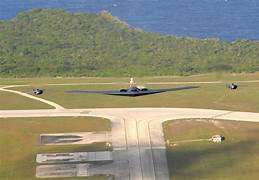 A pair of black planes flying over a runway

Description automatically generated