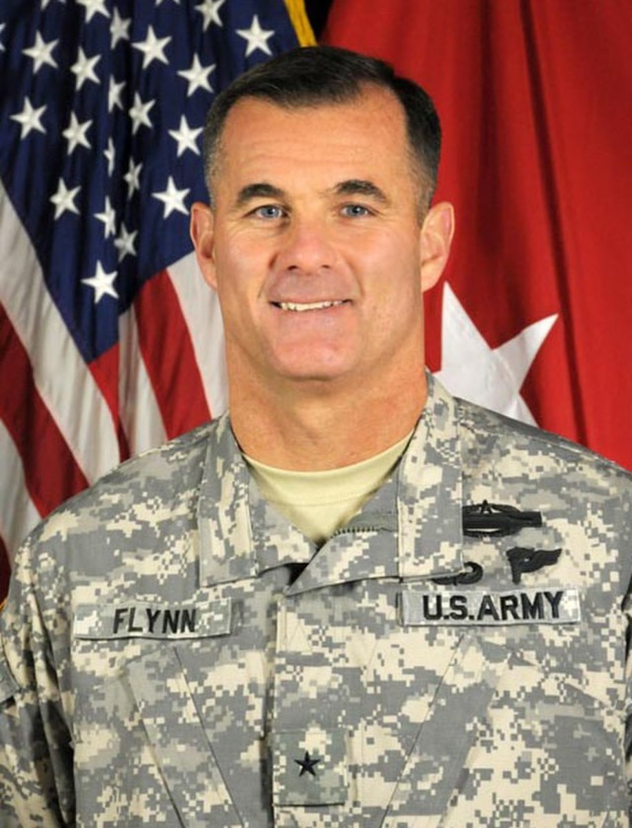 A person in military uniform in front of a flag

Description automatically generated