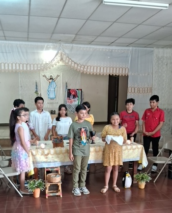 A group of children standing around a table
Description automatically generated