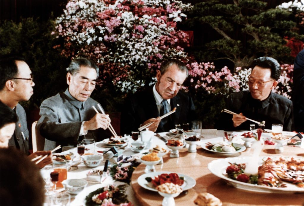 A group of men eating at a table Description automatically generated